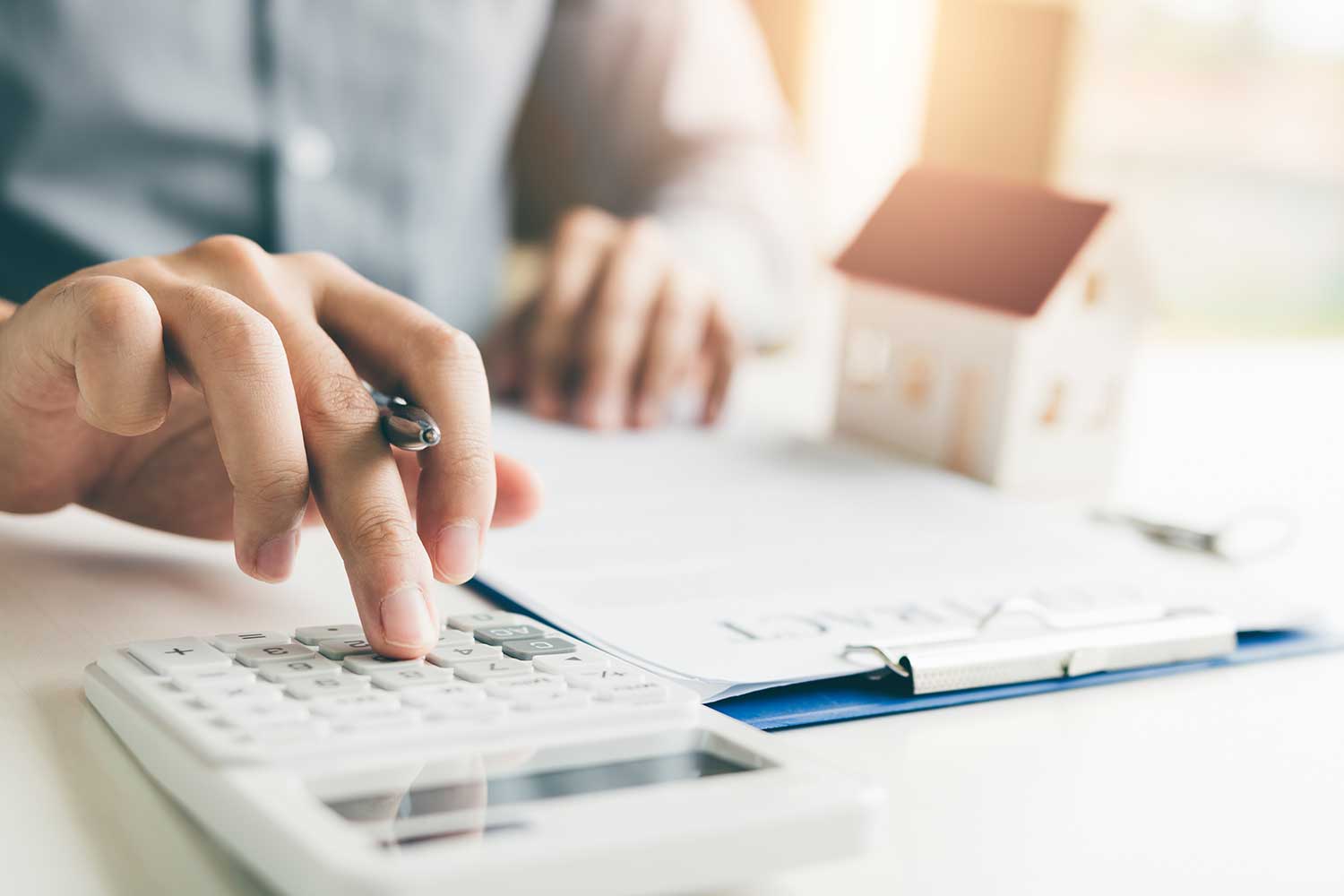 Home agents using calculator to calculate the return of a real estate investment