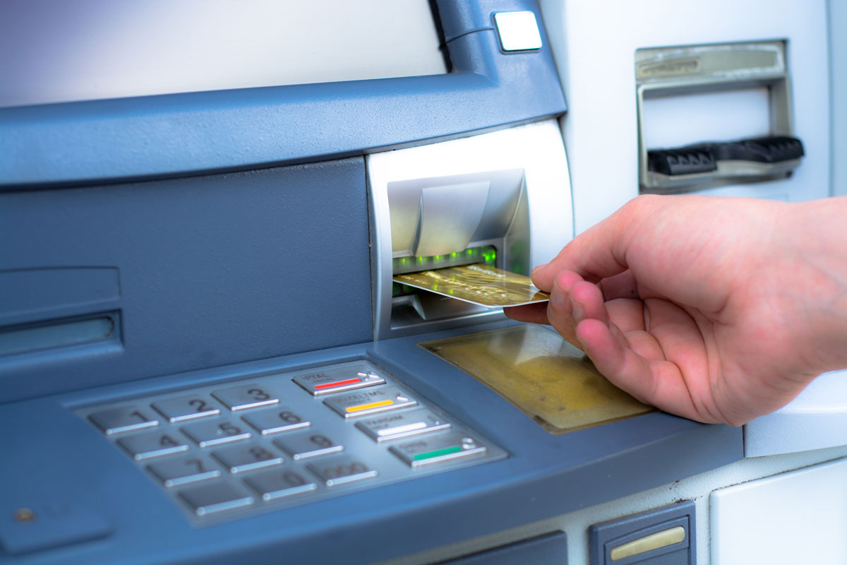Withdrawing Money from ATM Machine by businessman