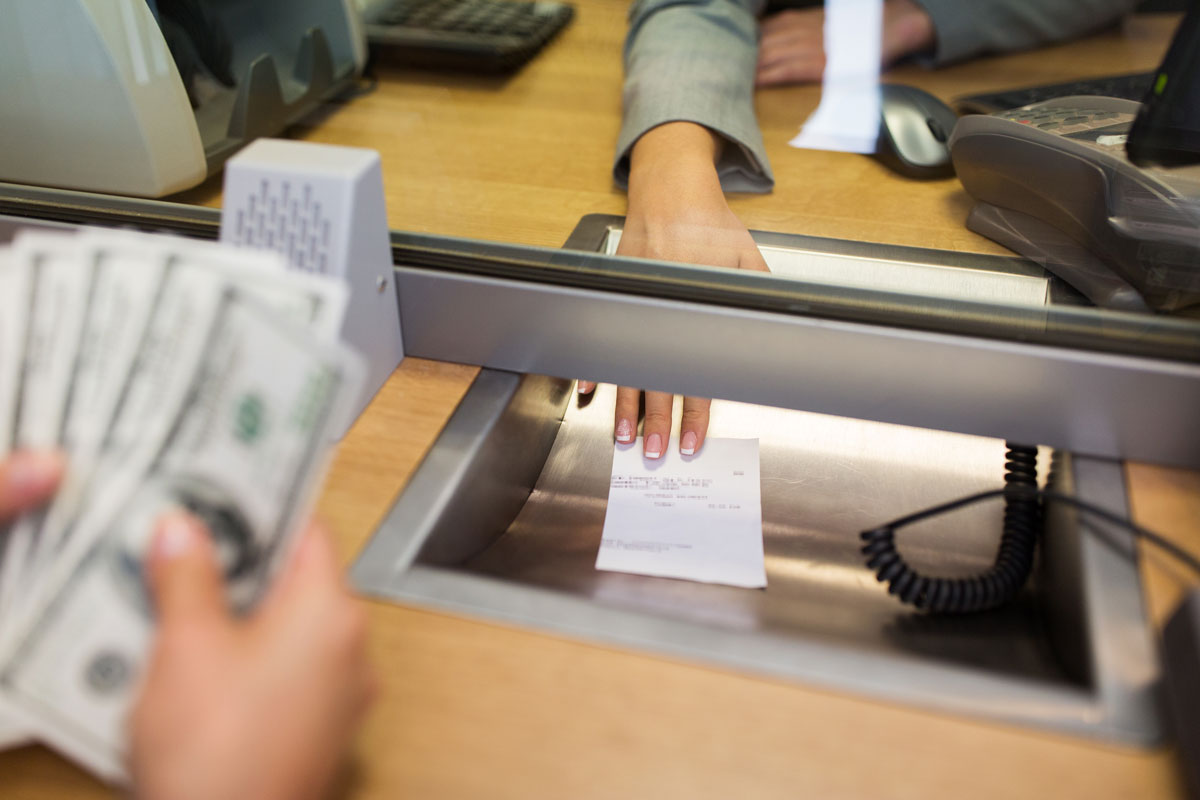 photo of a man getting money on a bank counter money cash counting bills
