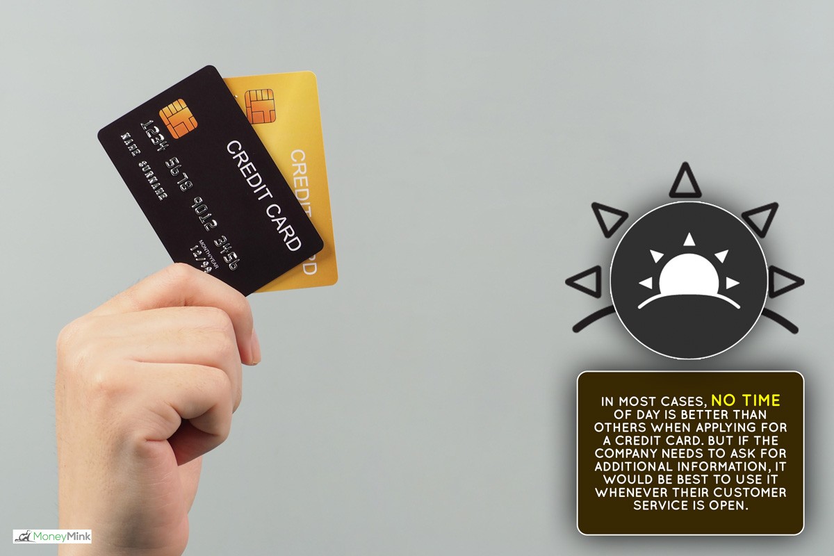 Hand is holding two credit card in black and gold color isolated on grey background., Best Time Of Day To Apply For Credit Card - Is There One?