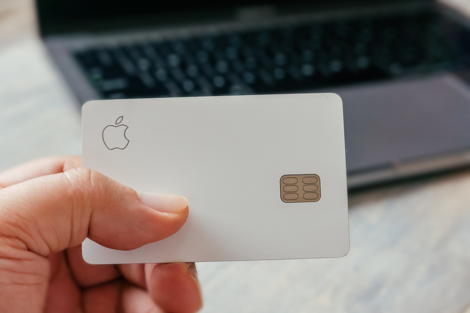 Physical Apple Credit Card Titanium with MacBook Pro ready to make an online purchase. Apple is a multinational technology company.