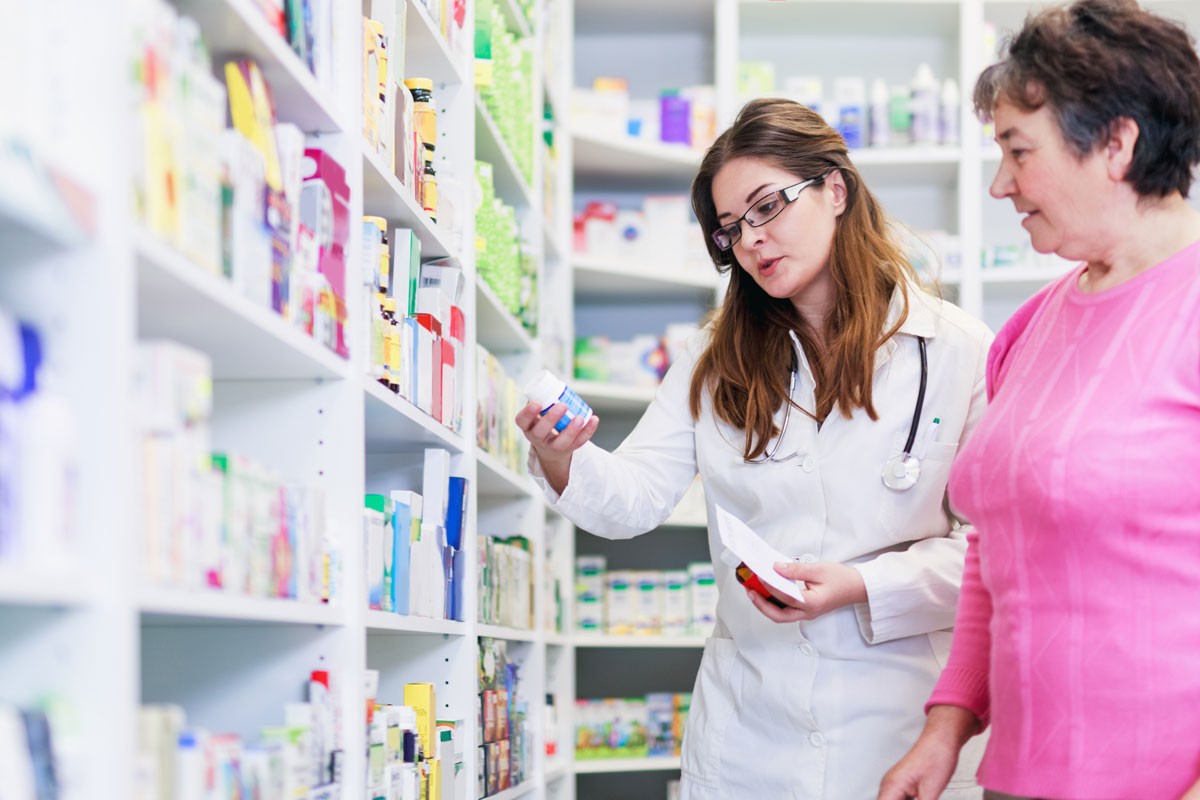 female pharmacist discusses prescription medication senior
